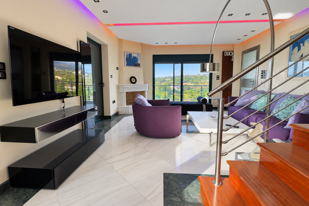 Living Room with Coloured Lighting Living room with television, purple seating and coloured ceiling lighting