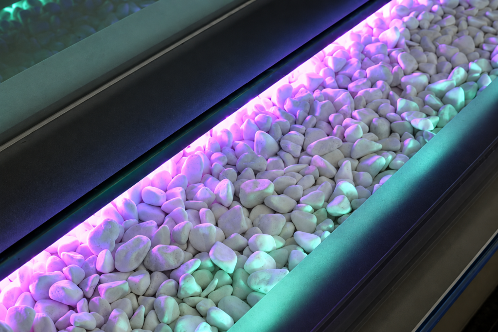 Architectural Lighting Detail Pebbles beneath glass with purple and green LED lighting