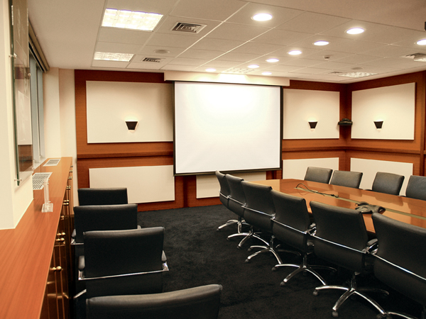 Οθόνη προβολής και τραπέζι συσκέψεων στο smart meeting room
