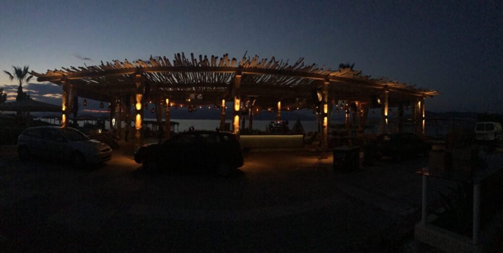 Beluga Beach Club — Εξωτερικό μπαρ με θερμό φωτισμό το σούρουπο Εξωτερικό μπαρ με θερμό φωτισμό το σούρουπο — Beluga Beach Club / Outdoor bar with warm lighting at dusk