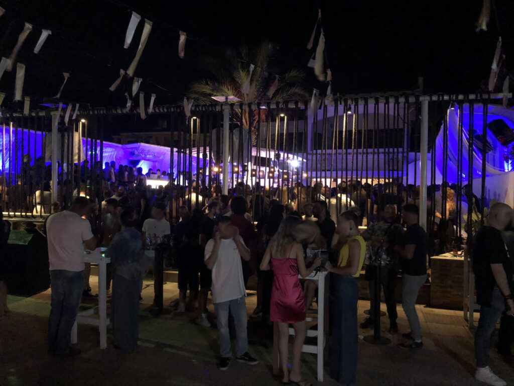 Beluga Beach Club — Μωβ φωτισμός στον χώρο εκδήλωσης με επισκέπτες Μωβ φωτισμός στον χώρο εκδήλωσης με επισκέπτες — Beluga Beach Club / Purple lighting in the event area with guests