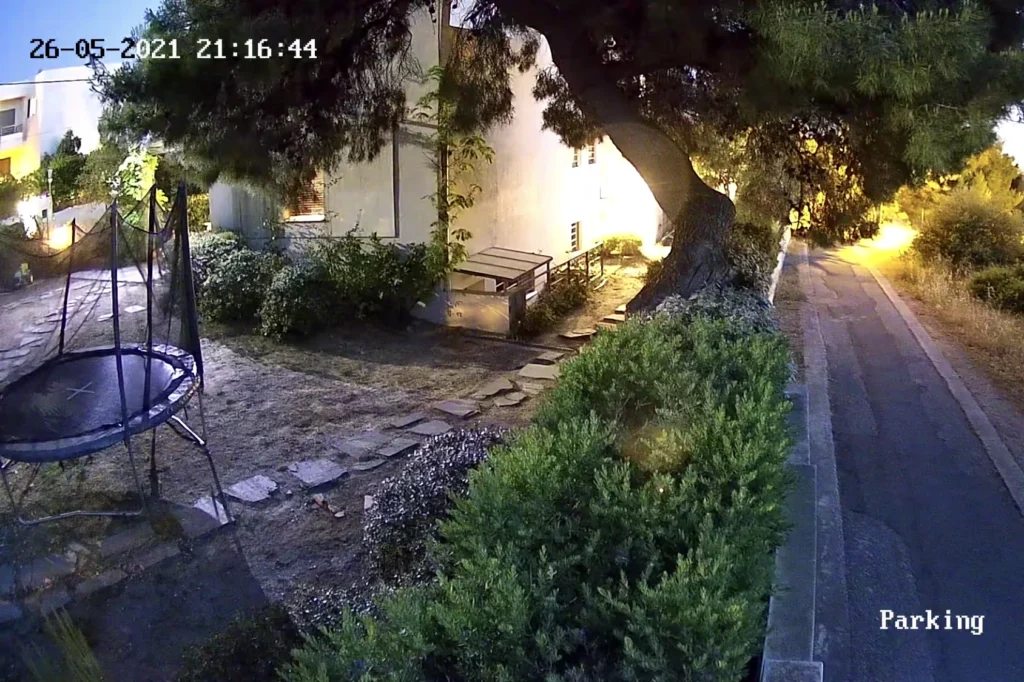 Έγχρωμο νυχτερινό στιγμιότυπο κήπου και χώρου στάθμευσης